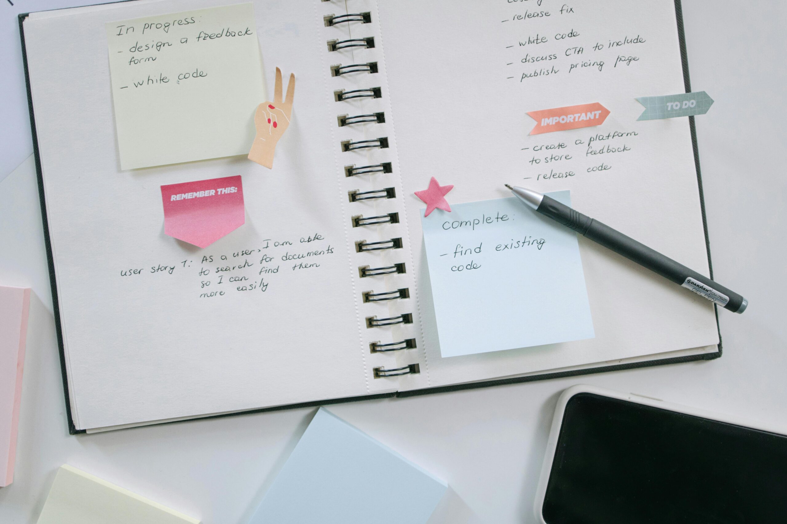 A modern workspace with a notebook, smartphone, and sticky notes emphasizing productivity and organization.